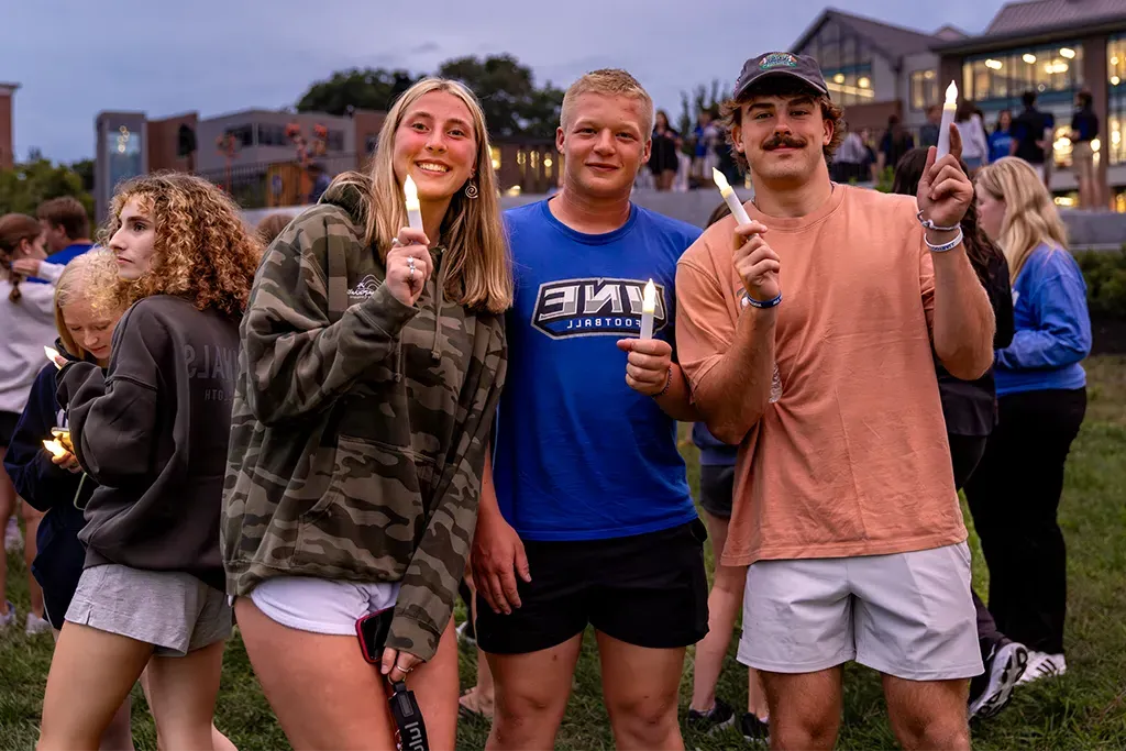 A group of undergraduate students hold fake candles for the First Night event on Biddeford campus